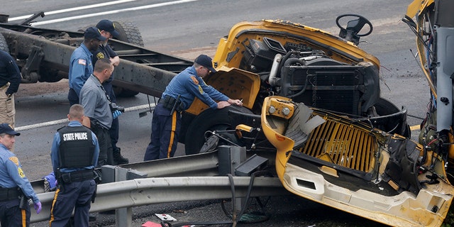 Emergency personnel examine a school bus after it collided with a dump truck, injuring multiple people, on Interstate 80 in Mount Olive, N.J., Thursday, May 17, 2018.