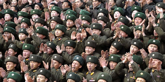 FILE - In this undated file photo released by the Korean Central News Agency and distributed in Tokyo by the Korea News Service on Jan. 21, 2012, military personnel clap as North Korean leader Kim Jong Un, unseen, visits the Korean People's Army (KPA) Unit 3870 at an undisclosed location in North Korea. Young Kim gets rock star treatment when he visits his troops, just as his father did. But while the late Kim Jong Il mostly stayed aloof in dark shades, his son holds hands and hugs. He seems to want to bond. (AP Photo/Korean Central News Agency via Korea News Service, File) JAPAN OUT UNTIL 14 DAYS AFTER THE DAY OF TRANSMISSION