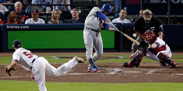 Los Angeles Dodgers Adrian Gonzalez (23) hits a two-run home run against the Atlanta Braves in the third inning of Game 1 of the National League Divisional Series, Thursday, Oct. 3, 2013, in Atlanta.  (AP Photo/Dave Martin)