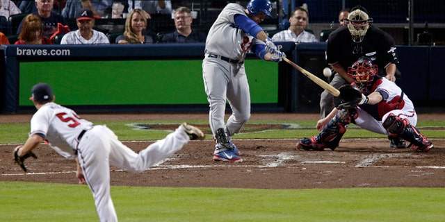 Los Angeles Dodgers Adrian Gonzalez (23) hits a two-run home run against the Atlanta Braves in the third inning of Game 1 of the National League Divisional Series, Thursday, Oct. 3, 2013, in Atlanta. (AP Photo/Dave Martin)
