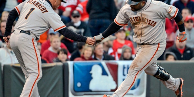 Oct. 10, 2012: San Francisco Giants' Pablo Sandoval is congratulated by third base coach Tim Flannery (1) after hitting a two-run home run against the Cincinnati Reds in the seventh inning of Game 4 of the National League division baseball series, in Cincinnati.