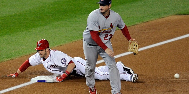 Oct. 12, 2012: Washington Nationals' Bryce Harper, back, slides into third base for a triple as the throw goes wide of St. Louis Cardinals third baseman David Freese in the first inning of Game 5 of the National League division baseball series in Washington.