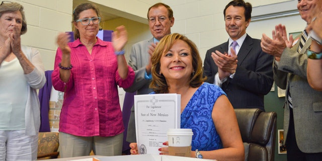 From left, New Mexico state Senator Mary Kay Papen, D-Las Cruces, Pamela Angell, executive director of St. Luke's Health Care Clinic, state Rep. Bealquin Gomez, D-La Mesa, Jon Barela, director of the New Mexico Economic Development Department, and state Senator Ron Griggs, R-Alamogordo applaud New Mexico Governor Susana Martinez, center, following the signing of a $294 million capital spending bill Wednesday, June 17, 2015, at St. Luke's Health Care Clinic in Las Cruces, New Mexico. St. Luke's was a recipient of $500,000 in capital outlay funds. (Anthony Albidrez/Las Cruces Sun-News via AP)