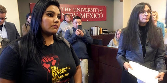 University of New Mexico student LuzHilda Campos, left, and Chicano studies professor Irene Vasquez, right, present a letter with hundreds of signatures on Friday, Nov. 18, 2016, to school president Bob Frank asking him to declare the campus a "sanctuary university," in Albuquerque, N.M. A group of professors at the largest university in the nation's most Hispanic state are asking for more protection of immigrant students following the election of Republican Donald Trump. (AP Photo/Russell Contreras)