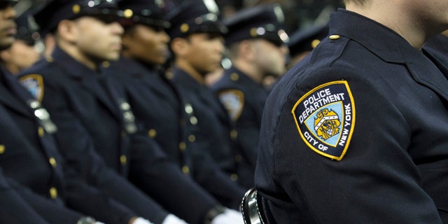 FILE- In this Dec. 29, 2014, file photo, new recruits attend their New York Police Academy graduation ceremony at Madison Square Garden in New York. (AP Photo/John Minchillo, File)
