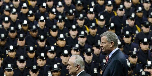 New York City Mayor Bill de Blasio, right, and NYPD police commissioner Bill Bratton, center, stand on stage during a New York Police Academy graduation ceremony, Monday, Dec. 29, 2014, at Madison Square Garden in New York. Nearly 1000 officers were sworn in as tensions between city hall and the NYPD continued following the Dec. 20 shooting deaths of officers Rafael Ramos and Wenjian Liu. (AP Photo/John Minchillo)
