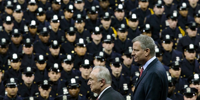 New York City Mayor Bill de Blasio, right, and NYPD police commissioner Bill Bratton, center, stand on stage during a New York Police Academy graduation ceremony, Monday, Dec. 29, 2014, at Madison Square Garden in New York. Nearly 1000 officers were sworn in as tensions between city hall and the NYPD continued following the Dec. 20 shooting deaths of officers Rafael Ramos and Wenjian Liu. (AP Photo/John Minchillo)