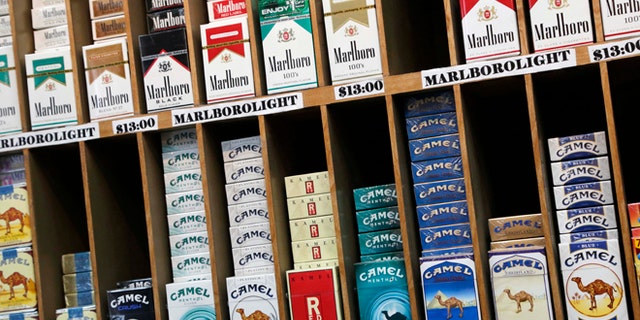 FILE- In this March 18, 2013 file photo, cigarette packs are displayed at a convenience store in New York. On Wednesday, Oct. 30, 2013, law makers in New York City voted to raise the cigarette-buying age from 18 to 21. (AP Photo/Mark Lennihan, File)