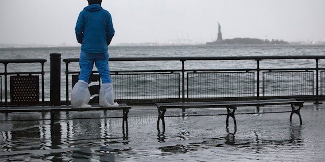 A man watches the rising tides in Battery Park as Hurricane Sandy makes its approach in New York October 29, 2012. Hurricane Sandy, the monster storm bearing down on the U.S. East Coast, strengthened on Monday after hundreds of thousands moved to higher ground, public transport shut down and the U.S. stock market suffered its first weather-related closure in 27 years. REUTERS/Andrew Kelly (UNITED STATES - Tags: ENVIRONMENT DISASTER)