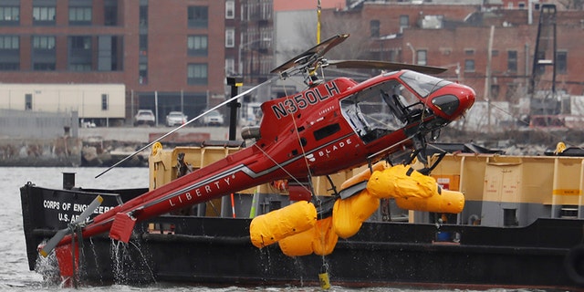 The wreckage of a chartered Liberty Helicopters helicopter that crashed into the East River is hoisted from the water in New York, U.S., March 12, 2018.