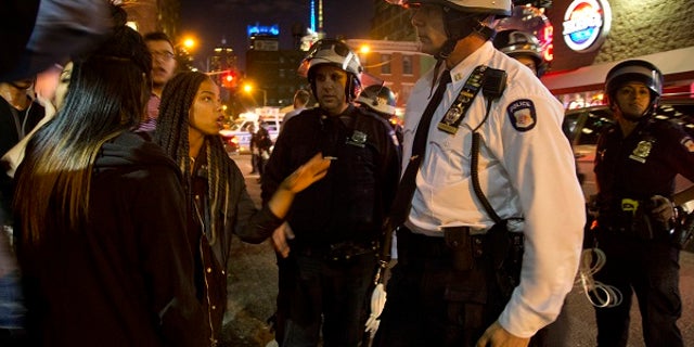 A New York City police captain listens to protesters as they demonstrate, Wednesday, April 29, 2015, in New York. Several hundred people gathered in New York on Wednesday to protest the death of Freddie Gray, a Baltimore man who was critically injured in police custody, and more than a dozen were arrested. (AP Photo/Julie Jacobson)