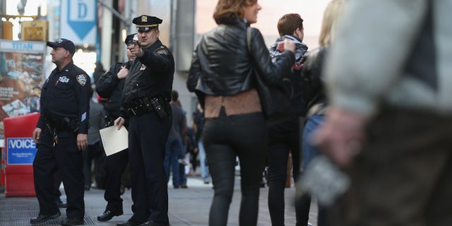 NEW YORK, NY - APRIL 15: New York Police Department officers gather at the edge of Times Square in Manhattan on April 15, 2013 in New York City. The city has announced it will implement heightened security measures in response to today's bombings at the Boston Marathon. (Photo by Mario Tama/Getty Images)