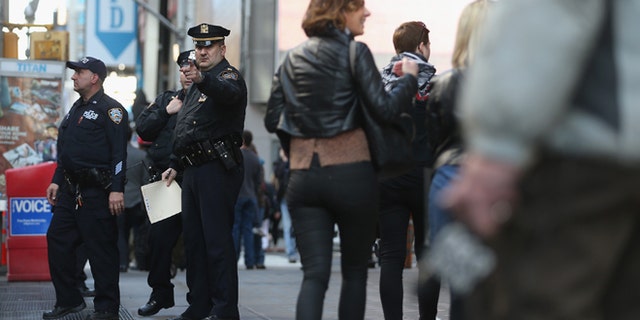 NEW YORK, NY - APRIL 15: New York Police Department officers gather at the edge of Times Square in Manhattan on April 15, 2013 in New York City. The city has announced it will implement heightened security measures in response to today's bombings at the Boston Marathon. (Photo by Mario Tama/Getty Images)