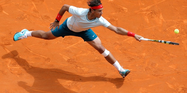 FILE - In this April 20, 2013 file photo, Spain's Rafael Nadal plays a return to France's Jo-Wilfried Tsonga during their semifinal match of the Monte Carlo Tennis Masters tournament in Monaco. Nadal already owns a record seven titles at Roland Garros. The French Open begins Sunday, May 26, 2013. (AP Photo/Lionel Cironneau, File)