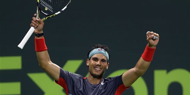 Spain's Rafael Nadal celebrates after winning the  final match of the Qatar Open tournament in Doha against France's Gael Monfils on Saturday, Jan. 4, 2014. (AP Photo/Osama Faisal)