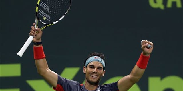 Spain's Rafael Nadal celebrates after winning the final match of the Qatar Open tournament in Doha against France's Gael Monfils on Saturday, Jan. 4, 2014. (AP Photo/Osama Faisal)
