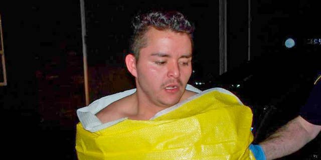 In this photo released by the Keizer, Ore., Police Department, 24-year-old Guillermo Brambila Lopez, of Woodburn, Ore., is wrapped in a blanket following his arrest, Sunday, Jan. 4, 2015. Police said Lopez broke into two homes in Keizer, drinking alcohol and using the hot tub at one of them. (AP Photo/Keizer Police Department)