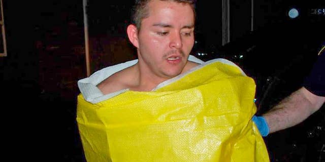 In this photo released by the Keizer, Ore., Police Department, 24-year-old Guillermo Brambila Lopez, of Woodburn, Ore., is wrapped in a blanket following his arrest, Sunday, Jan. 4, 2015. Police said Lopez broke into two homes in Keizer, drinking alcohol and using the hot tub at one of them. (AP Photo/Keizer Police Department)