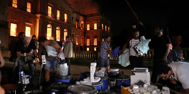 People work to rescue items during a fire at the National Museum of Brazil.