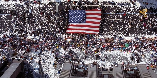 Marchers carry a giant American flag up Broadway in New York City on June 10, 1991 as part of a welcome home parade for veterans of Operation Desert Storm.