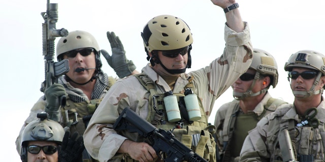 U.S. Navy SEAL Team 18 members react in recognition of contributions of former SEALs after a demonstration of combat skills at the National Navy UDT-SEAL Museum in Fort Pierce, Fla..