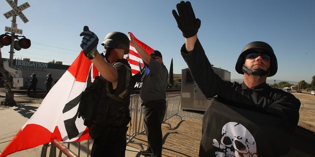 OCT. 24: File-Members of the white supremacist group, the National Socialist Movement, hold swastika flags and salute at the NSMÃs anti-illegal immigration rally near a Home Depot store in Riverside, California. (Photo by David McNew/Getty Images)