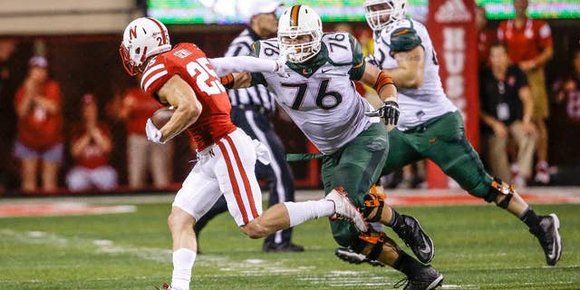 FILE - In this file photo from Sept. 20, 2014, Nebraska defensive back Nate Gerry (25) runs away from Miami offensive lineman Taylor Gadbois (76) after intercepting the ball in the second half of an NCAA college football game in Lincoln, Neb. Nebraska’s Gerry is back at safety and loving it. The sophomore, who played linebacker last season, is playing at an All-Big Ten level in the secondary, with interceptions in four of the Cornhuskers’ five conference games. (AP Photo/Nati Harnik, File)