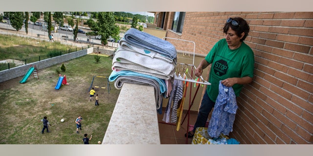 SALT, SPAIN - JUNE 05: Fifty-one year year old Doris Perez hangs out the clothes in the balcony of her apartment of an occupied newly constructed building where she moved last March with her three grandchildren after being evicted one year ago after being unable to afford to pay a rent on June 5, 2013 in Salt, Spain. In 2010 Spanish banks foreclosed on more than 100,000 households contributing to the already large number of empty houses in Spain. With as many as one million properties unsold victims of Spain's financial crisis have turned to squatting in the empty buildings. This building has stood empty for two years before the anti-eviction platform of Girona and several homeless families moved in three months ago. The community houses a total of 8 families who have to suffer water and electricity cuts and live with the fear of eviction. (Photo by David Ramos/Getty Images)