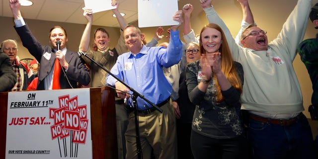State Sen. Charlie Jansssen of Fremont, second left, Jeremy Jensen, third left, and John Wiegert, center, celebrate with other activists in Fremont, Neb., Tuesday, Feb. 11, 2014, after city voters have decided by voting no, to uphold the law designed to bar immigrants from renting homes if they dont have legal permission to be in the U.S. (AP Photo/Nati Harnik)