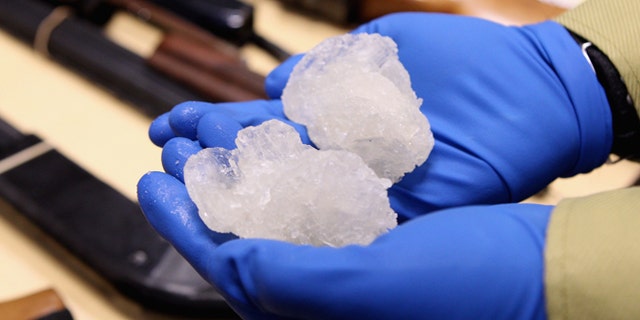 AUCKLAND, NEW ZEALAND - AUGUST 19: Detective Paul Baker holds two rocks of crystal meth with a street value of NZD$83,000 alongside firearms that were confiscated as part of Operation Slab at the North Shore Policing Centre on August 19, 2010 in Auckland, New Zealand. Police executed 22 search warrants across New Zealand and raided six crime labs resulting in the seizure of 140 grams of crystal meth, weapons and drug manufacturing equipment. Ten suspects were arrested as a part of the raid and will appear in the Auckland District Court. (Photo by Phil Walter/Getty Images) *** Local Caption *** Paul Baker