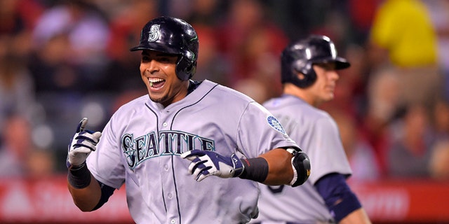 Seattle Mariners' Nelson Cruz, left, celebrates after hitting a solo home run against the Los Angeles Angels as Logan Morrison walks up to bat during the seventh inning of a baseball game, Monday, May 4, 2015, in Anaheim, Calif. Morrison also hit a solo home run in the inning. (AP Photo/Mark J. Terrill)