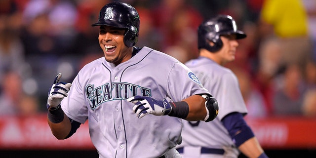 Seattle Mariners' Nelson Cruz, left, celebrates after hitting a solo home run against the Los Angeles Angels as Logan Morrison walks up to bat during the seventh inning of a baseball game, Monday, May 4, 2015, in Anaheim, Calif. Morrison also hit a solo home run in the inning. (AP Photo/Mark J. Terrill)