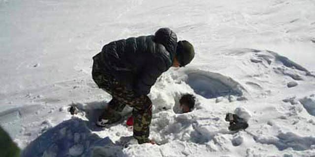 October 19, 2014: In this photo provided by the Nepalese army, a soldier searches for avalanche victims at Thorong La pass. (AP Photo/Nepalese Army)