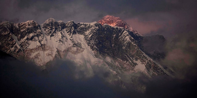FILE - In this Oct. 27, 2011 file photo, the last light of the day sets on Mount Everest as it rises behind Mount Nuptse as seen from Tengboche in the Himalays, Khumbu region, Nepal. (AP Photo/Kevin Frayer, File)