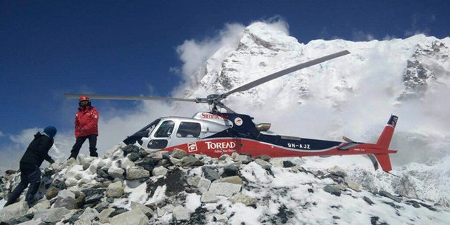 A helicopter prepares to rescue people from camp 1 and 2 at Everest Base Camp, Nepal. On Monday, State Department officials confirmed the death of two Americans at the base camp from a large avalanche triggered by Nepal's massive earthquake. (Azim Afif via AP)