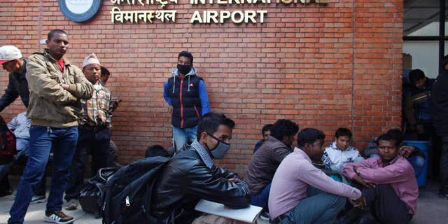 Stranded passengers wait for an update on their flights at Tribhuwan International Airport in Kathmandu, Nepal, Wednesday, March 4, 2015. A Turkish Airlines jet landing in dense fog in the Nepalese capital Wednesday skidded off a slippery runway but there were no serious injuries, officials said. The only international airport in Nepal remained closed Wednesday morning after the accident. (AP Photo/Niranjan Shreshta)
