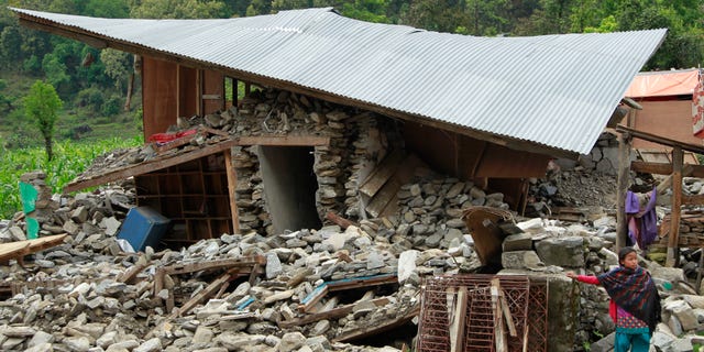 April 30, 2015 - A girl waits for relief aid outside her collapsed home in the destroyed village of Balua, near the epicenter of Saturday's massive quake, in Nepal's Gorkha District. Life edged back to a semblance of normal in Kathmandu Friday as residents packed tents and moved indoors and rescuers continued to comb the rubble for survivors.
