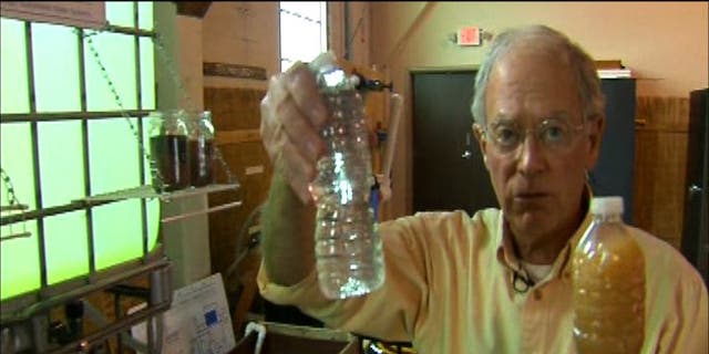 Water Missions International co-founder and CEO George Greene holds samples of water taken after and before the purification process.