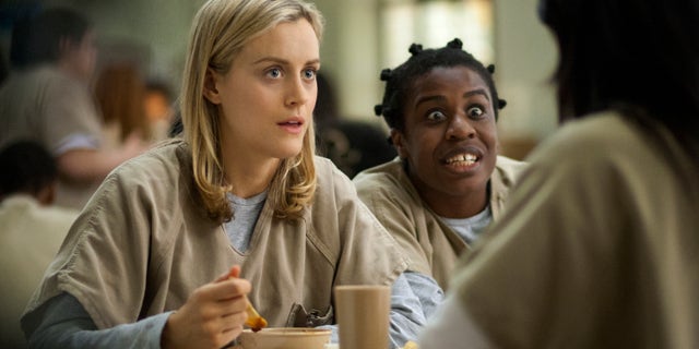 This image released by Netflix shows Taylor Schilling, left, and Uzo Aduba in a scene from 'Orange Is the New Black.'