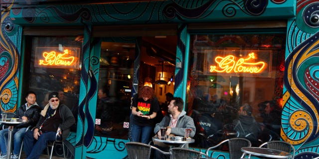 FILE - In this Oct. 31, 2011 file photo customers are seen outside the coffee shop The Green House in Amsterdam, Netherlands. With slogans like Dont let your vote go up in smoke!, owners of the free-wheeling cafes where bags of hashish are sold alongside cups of coffee are mounting a get-out-the-stoner-vote campaign to encourage the drugged up stoned voters ahead of next week's Dutch election. The campaigners are calling on their sometimes apathetic dope smoking clientele to get out and support political parties that oppose the recently introduced "weed pass" that is intended to rein in the cafes.(AP Photo/Peter Dejong, File)