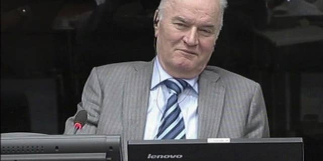 FILE - In this Jan. 28, 2014 file image taken from video former Bosnian Serb military chief Gen. Ratko Mladic smiles during his appearance at the Yugoslav war crimes tribunal in the Hague, Netherlands. On Monday, May 19, 2014 Mladic has launched the defense case in his long-running U.N. trial by calling a former Serb army officer who claims he was never ordered to fire on civilians in the besieged Bosnian capital. The 72-year-old Mladic denies 11 charges of ordering Serb atrocities throughout the 1991-95 Bosnian war. He faces a life sentence if convicted. (AP Photo/ICTY, Via Associated Press Television, File) TV OUT