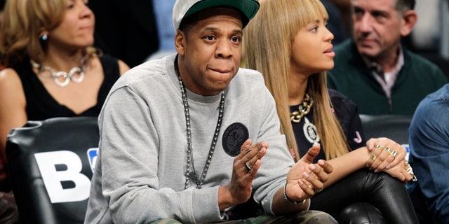 In this Nov. 26, 2012, file photo, rap mogul and Brooklyn Nets minority owner Jay-Z and his wife, Beyonce, watch an NBA basketball game between the Nets and the New York Knicks at Barclays Center in New York. Jay -Z is selling his stake in the Nets so he can become certified as a player agent, possibly before the end of the season.