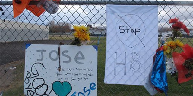 Friends have added a message to Jose Reyes and a small wooden cross at a memorial pictured Monday, Oct. 28, 2013, outside Sparks Middle School, where the seventh-grader fatally shot a teacher and wounded two 12-year-old classmates before killing himself in the school yard a week ago. Students returned to classes Monday for the first time since the Oct. 21 shooting. (AP Photo/By Scott Sonner)