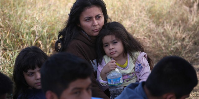 A Honduran mother holds her daughter, 3, after she turned her family in to U.S. Border Patrol agents on December 8, 2015 near Rio Grande City, Texas. They had just illegally crossed the U.S.-Mexico border into Texas. (Photo by John Moore/Getty Images)