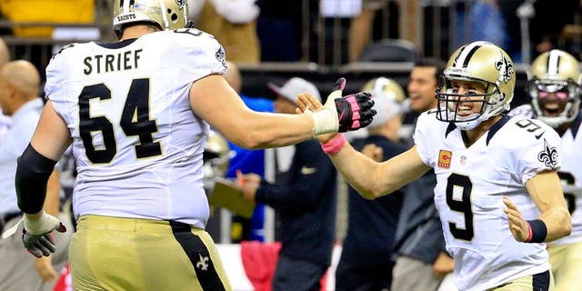 Oct 4, 2015; New Orleans, LA, USA; New Orleans Saints quarterback Drew Brees (9) and tackle Zach Strief (64) celebrates following an 80 yard game winning touchdown pass during overtime against the Dallas Cowboys at the Mercedes-Benz Superdome. The Saints won 26-20. The touchdown pass by Brees was the 400th touchdown pass of his career. Mandatory Credit: Derick E. Hingle-USA TODAY Sports