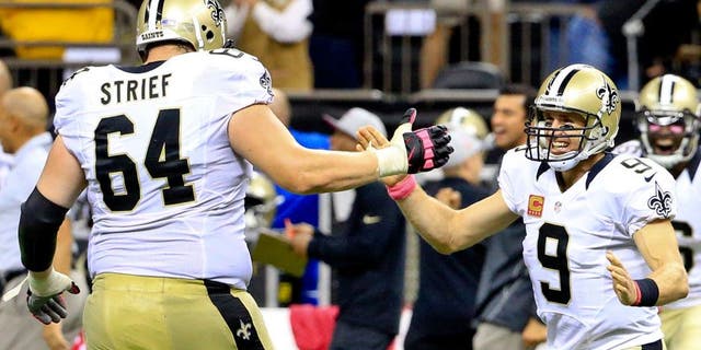 Oct 4, 2015; New Orleans, LA, USA; New Orleans Saints quarterback Drew Brees (9) and tackle Zach Strief (64) celebrates following an 80 yard game winning touchdown pass during overtime against the Dallas Cowboys at the Mercedes-Benz Superdome. The Saints won 26-20. The touchdown pass by Brees was the 400th touchdown pass of his career. Mandatory Credit: Derick E. Hingle-USA TODAY Sports