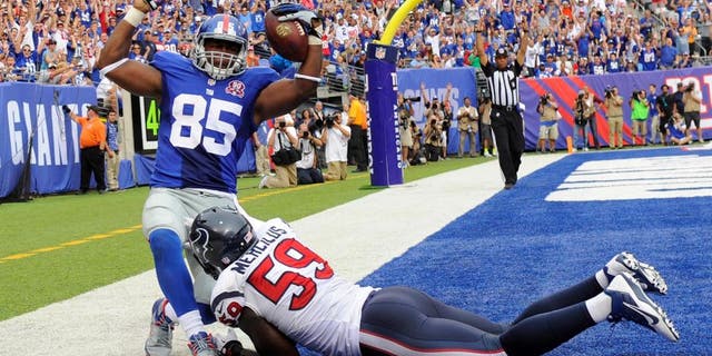 Sep 21, 2014; East Rutherford, NJ, USA; New York Giants tight end Daniel Fells (85) scores a touchdown against Houston Texans outside linebacker Whitney Mercilus (59) at MetLife Stadium. Mandatory Credit: Robert Deutsch-USA TODAY Sports