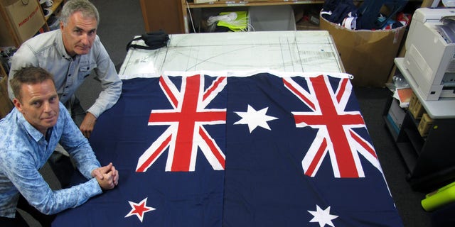 March 3, 2014 - FILE photo of Victor Gizzi, left, and David Moginie, managers at flag manufacturer Flagmakers, next to flags of New Zealand, left, and Australia, in their factory near Wellington, New Zealand. Fresh off a big election win, New Zealand Prime Minster John Key says he wants the nation to vote next year on changing its flag.