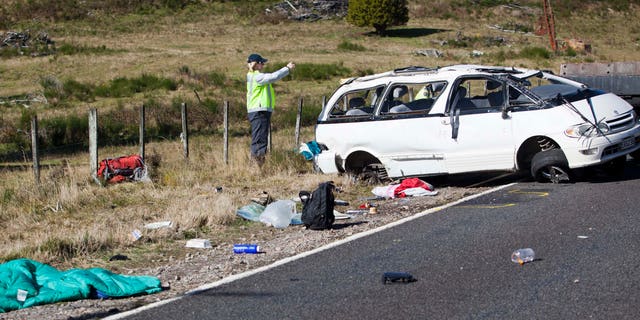 May 12, 2012: Policemen examine the scene of a minivan crash near Turangi, New Zealand, Saturday.