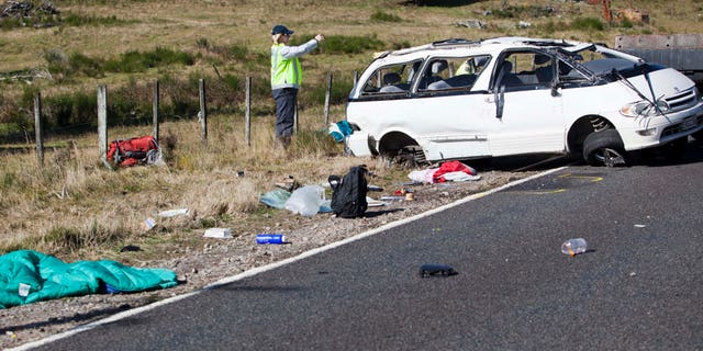 May 12, 2012: Policemen examine the scene of a minivan crash near Turangi, New Zealand, Saturday.